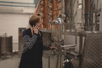Arbeiterin telefoniert in der Fabrik — Stockfoto