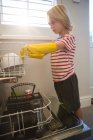 Хлопчик організовує посуд на кухонному візку вдома — стокове фото