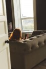 Жінка використовує мобільний телефон у вітальні вдома — стокове фото