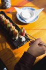 Primo piano della donna che mangia sushi al ristorante — Foto stock