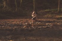 Задуманная женщина, сидящая в лесу осенью — стоковое фото