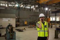 Ingénieur maritime parlant sur téléphone portable en atelier — Photo de stock