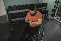 Инвалид наблюдает за временем на наручных часах в спортзале — стоковое фото