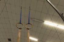 Athlète femme suspendue sur l'anneau de gymnastique à la salle de fitness — Photo de stock