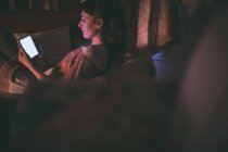 Жінка використовує цифровий планшет на дивані у вітальні вдома — стокове фото