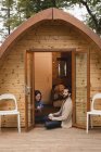 Happy couple having coffee outside log cabin — Stock Photo