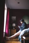 Donna che utilizza il telefono cellulare in camera da letto a casa — Foto stock