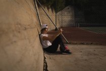 Junge Frau benutzt Handy auf dem Basketballplatz — Stockfoto