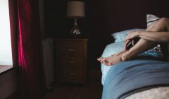 Frau entspannt sich auf einem Bett im Schlafzimmer zu Hause — Stockfoto