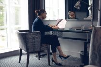Frau benutzte Laptop am Tisch im Hotelzimmer — Stockfoto