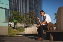 Jovem empresário ouvindo música no celular no escritório — Fotografia de Stock