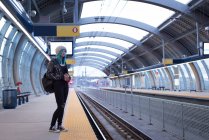 Стильна жінка чекає на поїзд на залізничній платформі — стокове фото