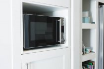 Primo piano del forno a microonde in armadio a casa — Foto stock