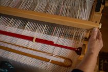Primer plano de la mujer mayor tejiendo seda en la tienda - foto de stock