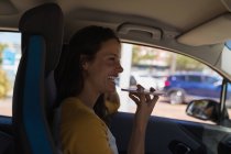 Schöne Frau, die im Auto mit dem Handy telefoniert — Stockfoto