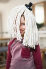 Happy boy with mop on head in kitchen at home — Stock Photo