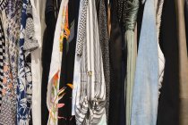 Close-up of various female clothes hanging in hangers at home — Stock Photo