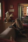 Продумана зріла жінка сидить на дивані вдома — стокове фото