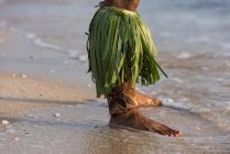 Sección baja de macho intérprete tradicional hawaiano de pie en la arena de la playa - foto de stock