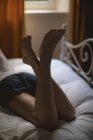 Visão traseira da mulher deitada na cama em casa — Fotografia de Stock