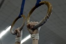 Athlète femme suspendue sur l'anneau de gymnastique à la salle de fitness — Photo de stock