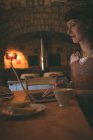 Жінка використовує ноутбук під час сніданку вдома — стокове фото