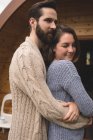 Close-up de casal afetuoso abraçando uns aos outros fora da cabine de madeira — Fotografia de Stock