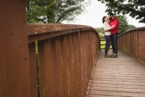 Прихильна пара стоїть на пішохідному мосту — стокове фото
