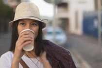 Удумлива жінка з кавою на міській вулиці — стокове фото