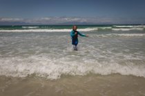 Menina feliz correndo no mar na praia — Fotografia de Stock