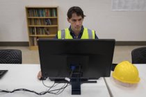 Работник-мужчина, работающий за компьютером в офисе солнечной станции — стоковое фото