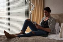 Mann nutzt digitales Tablet zu Hause im Schlafzimmer — Stockfoto