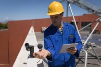 Male worker working at solar station on a sunny day — Stock Photo
