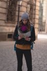Молодая женщина смотрит на карту на улице — стоковое фото