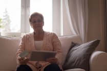 Seniorin beim Online-Einkauf auf digitalem Tablet zu Hause — Stockfoto