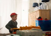 Хлопчик грає з іграшками у вітальні вдома — стокове фото