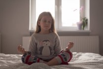 Menina realizando ioga no quarto em casa — Fotografia de Stock