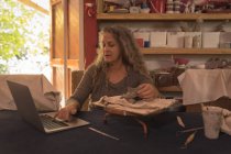 Женщина гончар с помощью ноутбука на дому — стоковое фото