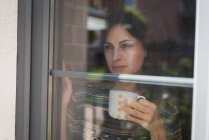 Задумчивая женщина-руководитель пьет кофе в офисе — стоковое фото