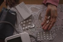 Close-up of senior woman holding medicine pill — Stock Photo