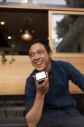Homme d'affaires souriant parlant au téléphone dans le café trottoir — Photo de stock