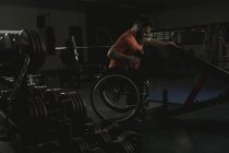 Інваліди чоловік на інвалідному візку розробки з в тренажерному залі Гантель — стокове фото