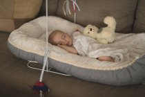 Niedliches kleines Baby schläft im Kinderbett auf dem Sofa zu Hause — Stockfoto