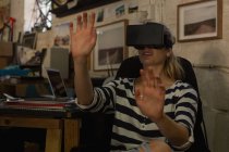 Молодая женщина-механик, использующая гарнитуру виртуальной реальности в мастерской — стоковое фото