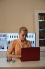 Молода жінка-косметолог використовує ноутбук у вітальні — стокове фото