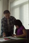 Father assisting her daughter in doing homework at home — Stock Photo
