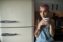Young woman drinking coffee in kitchen at home. — Stock Photo