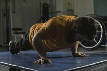 Homem deficiente fazendo flexões no ginásio — Fotografia de Stock