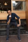 Усміхнений бізнесмен розмовляє по телефону в тротуарному кафе — стокове фото