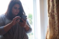 Schöne weibliche Vloggerin mit Handy zu Hause — Stockfoto